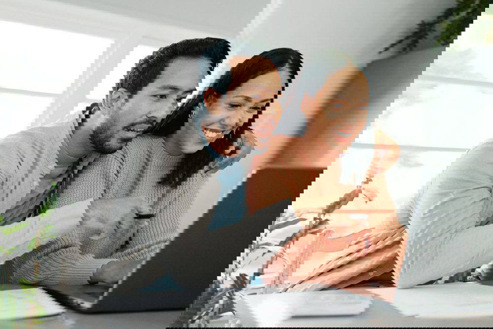 A couple looking at a laptop screen.